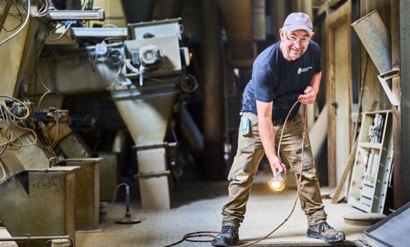 Mann, der im Silo eine Probe entnimmt