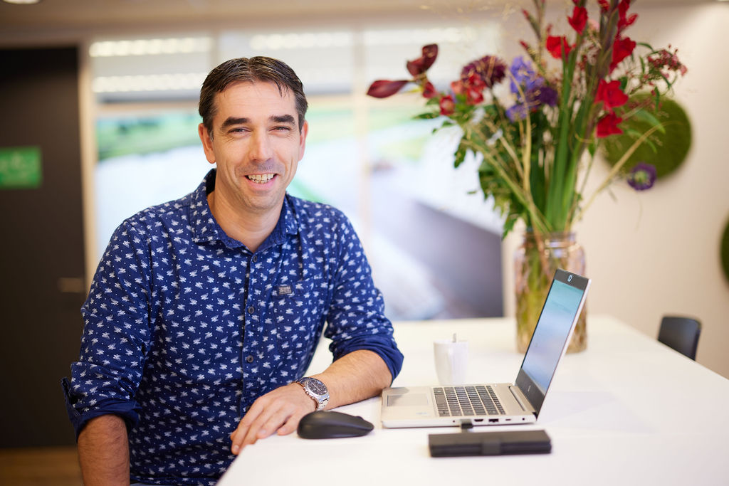 Man standing at table with laptop